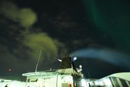Gelbliche Wolken, bläulicher Rauch und grünes Polarlicht über Båtsfjord (© Monika Maintz)